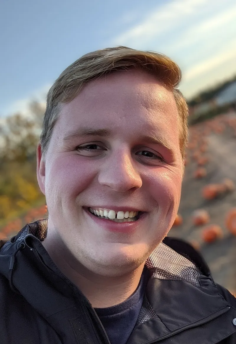 Bryce Clark smiling outdoors at a pumpkin patch